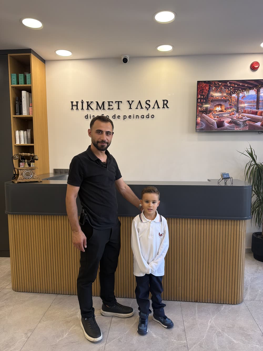 Hikmet Yaşar Kuaför resepsiyonunda ekipten bir kuaför ve çocuk misafir